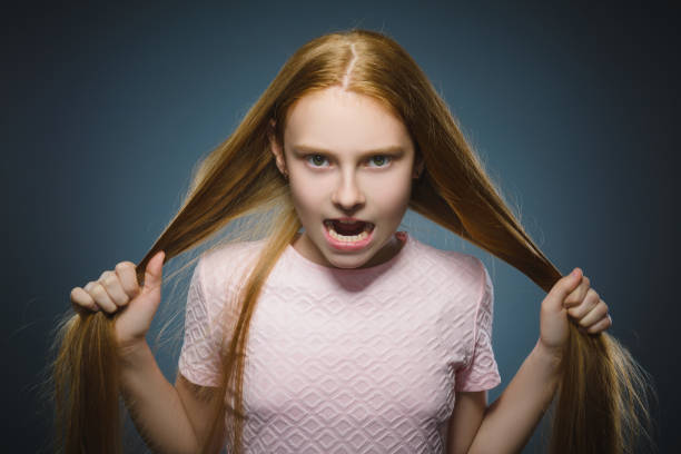 angry redhead girl isolated on gray background. stock photo