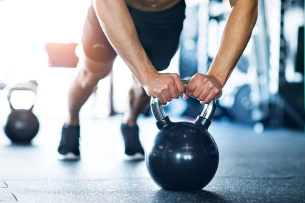 unkenntlich fit mann im fitnessraum tun push ups auf kettlebells - kugelhantel stock-fotos und bilder