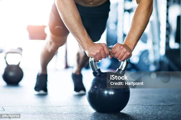 Unrecognizable Fit Man In Gym Doing Push Ups On Kettlebells Stock Photo - Download Image Now