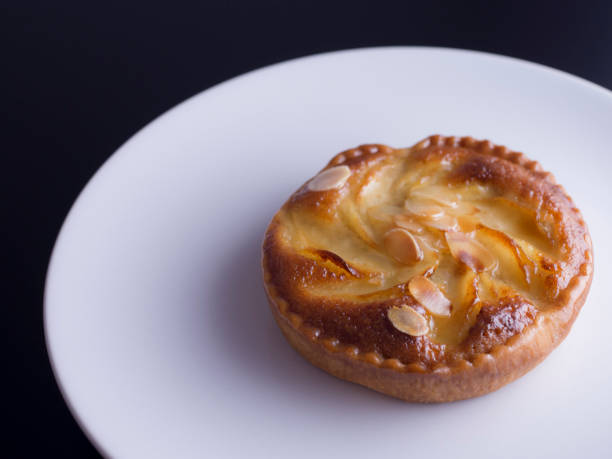 istock Almond and pear tart on black background 694051398