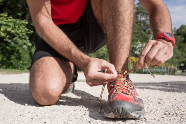 istock Close-up of man runner lacing his shoes 694054428