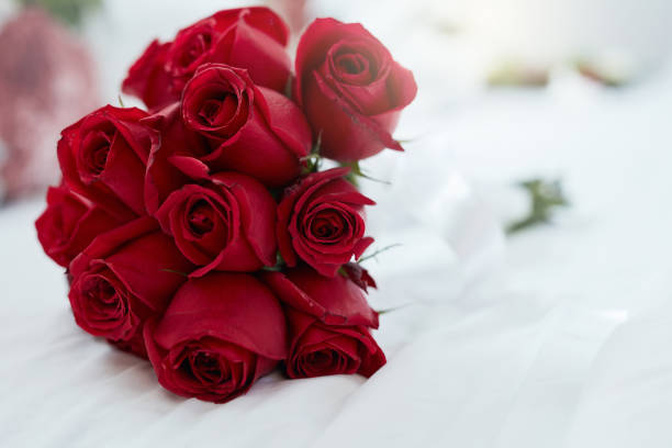 Shot of a bunch of red roses lying on a bed