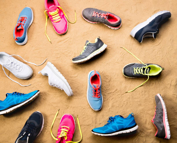 istock Various sports shoes laid on sand beach, studio shot 694061348