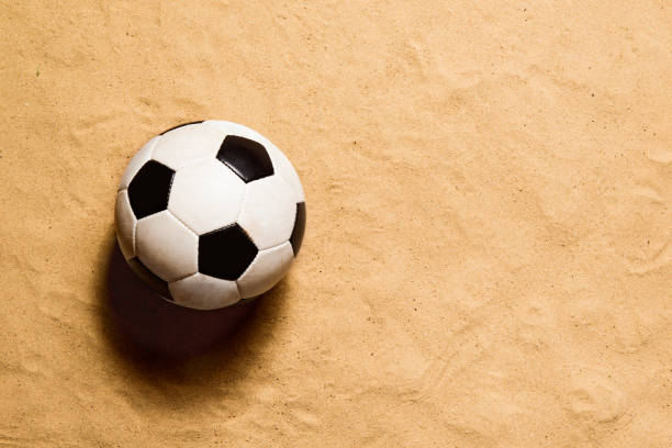 soccer ball against sandy beach. studio shot. copy space. - beach football imagens e fotografias de stock
