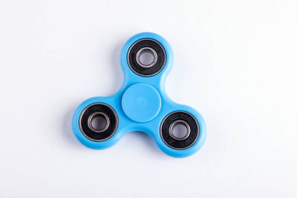 istock Blue fidget spinner stress relieving toy on white background 694061522