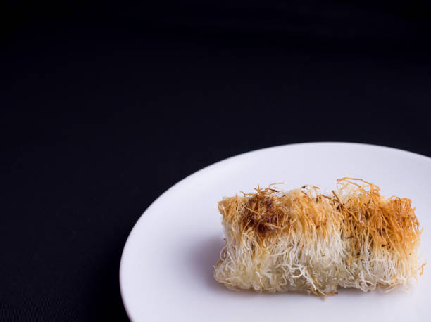 istock Kataifi pastry cake isolated on black 694061648