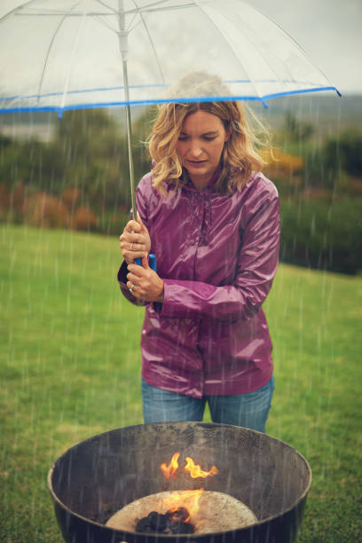 炎を燃やし続ける - rain drenched one person standing ストックフォトと画像