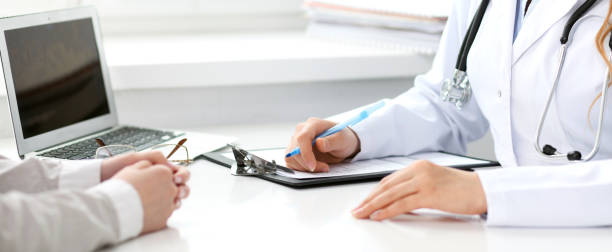 istock Doctor and  patient  sitting at the desk 694073476