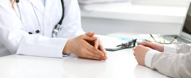 istock Doctor and  patient  sitting at the desk 694073556