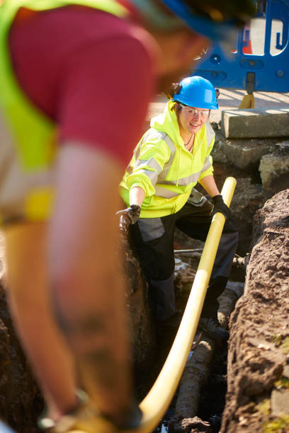 gas pipeline renewal a female gas engineer directs her male colleague whilst replacing old gas pipelines underground pipeline stock pictures, royalty-free photos & images