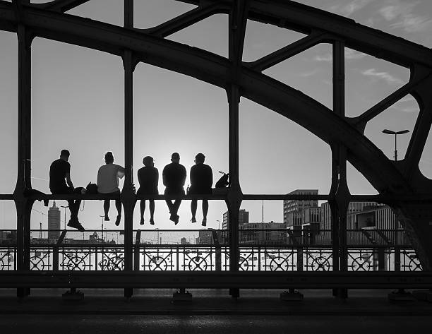 istock Silhouette Friend Relaxing On Railing At Bridge Against Sky During Sunny Day 694082385