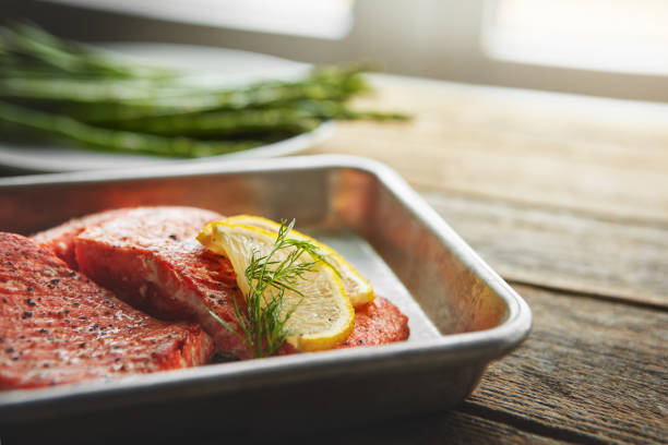 Shot of a piece of fish garnished with slices of lemon and fresh leaves in a dish