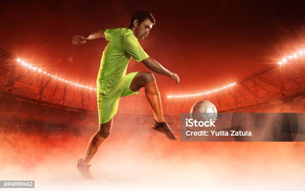 Soccer Player Hits A Ball On A Soccer Field Stock Photo - Download Image Now - Red Background, Soccer Player, Floodlight