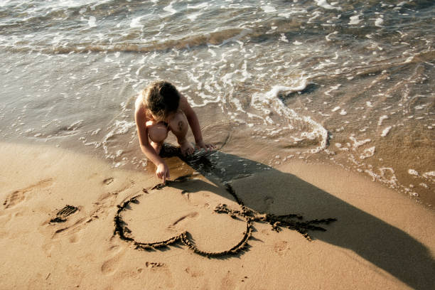 istock little girl playing on sandy beach 694090474