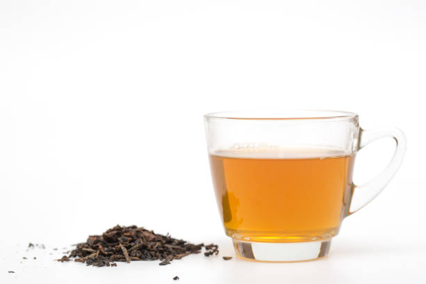 istock tea glass and tea leaves on white background 694090776
