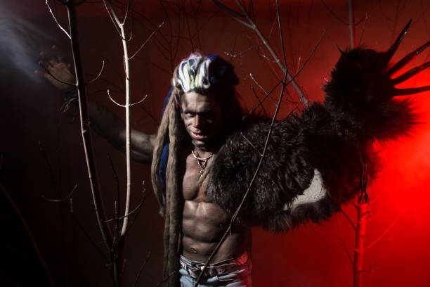 istock Werewolf with long nails among the branches of the tree and smoke 694090896