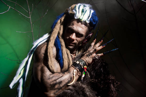 istock Werewolf with long nails among the branches of the tree and smoke. 694090898