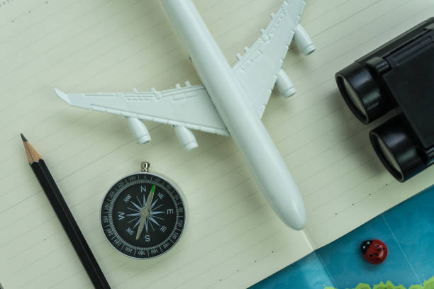 istock Travel concept with toy aircraft, compass, binoculars, pencil, paper note and map 694091486