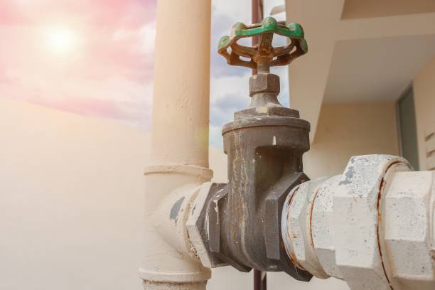 istock Water valve Close up, The rust Water valve, and pipe outside a building with sunset light tone. 694095228