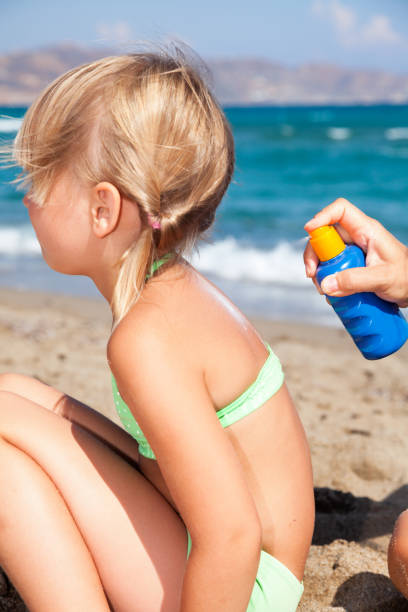 istock Mother applying sunscreen to her child at a beach 694099056