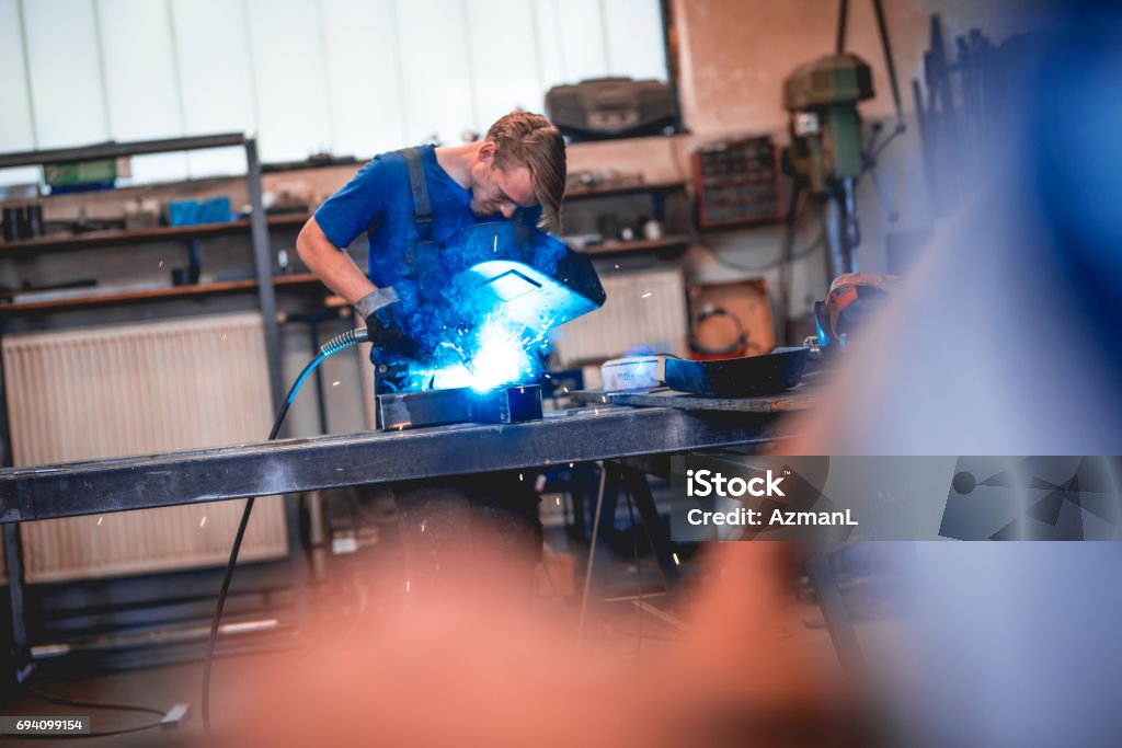 I'm getting better and better at welding Young worker is welding in a workshop. Adult Stock Photo