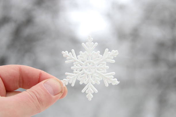istock winter, snow, christmas idea, hand holding a snowflake 694105394