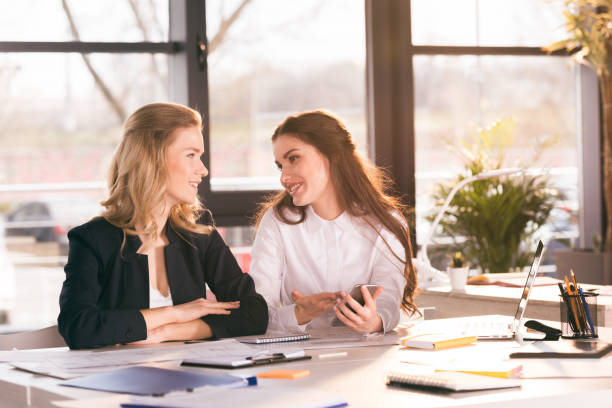 istock portrait of colleagues using digital smartphone while sitting at workplace 694106062