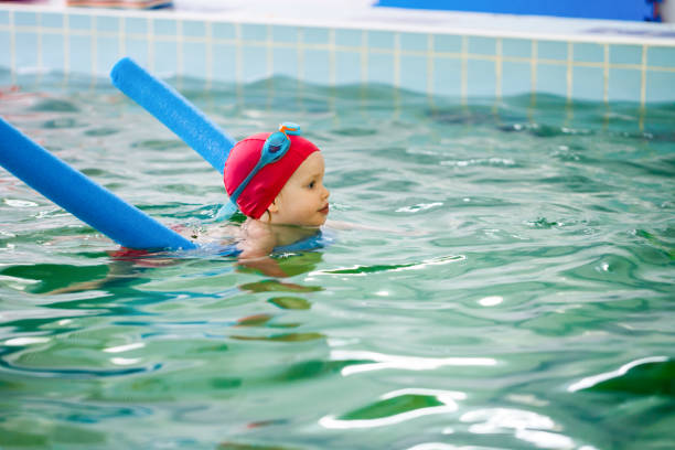 bambina che impara a nuotare in piscina - wading child water sport clothing foto e immagini stock