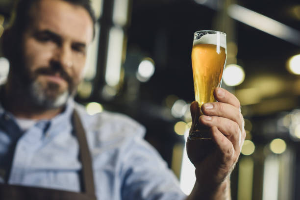 istock Brewery worker with glass of beer 694109942