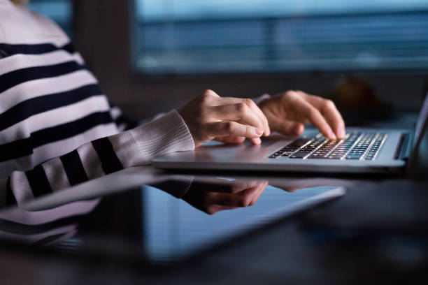 istock Unrecognizable woman sitting at desk working on laptop. 694113450