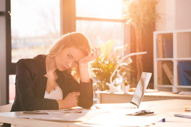 istock stressed businesswoman sitting at workplace and working in modern office 694114094