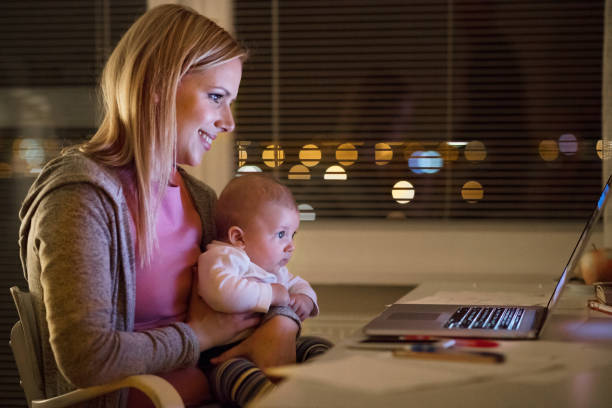 istock Mother with son in the arms, working on laptop 694114196