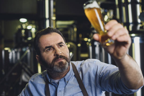 istock Brewery worker with glass of beer 694116862