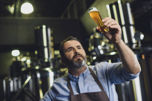 istock Brewery worker with glass of beer 694116958