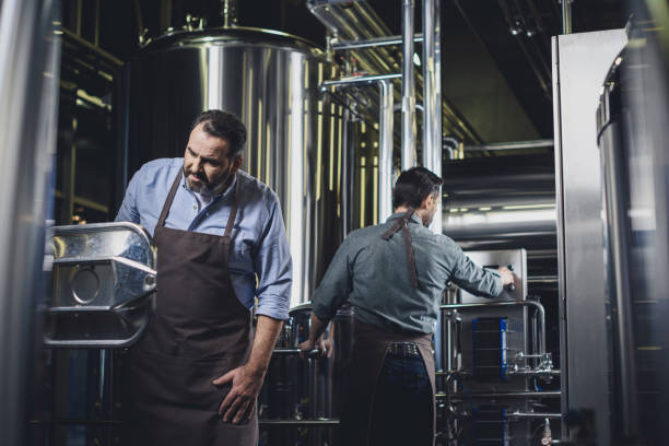istock Brewers working with industrial equipment 694117156