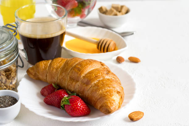 istock Healthy breakfast set: croissant, berries, and coffee. Selective 694121068