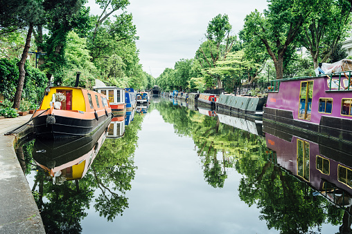 London, United Kingdom - May 23, 2017 : Houseboats, Little Venice. Little Venice is a scenic and affluent part of London, known for its canals and moored boats. Much of the property in the area consists of Regency-style white painted stucco terraced town houses and mansions.