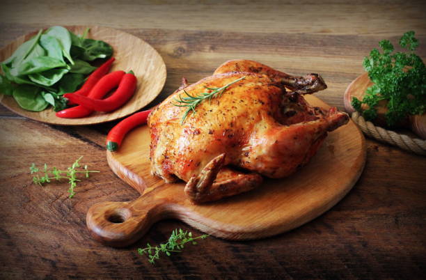 istock Whole roasted chicken on cutting board. Vintage photo 694139278