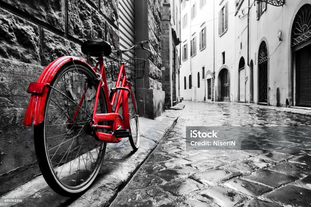 Retro vintage red bike on cobblestone street in the old town. Color in black and white Retro vintage red bike on cobblestone street in the old town. Color in black and white. Old charming bicycle concept. Black And White Stock Photo