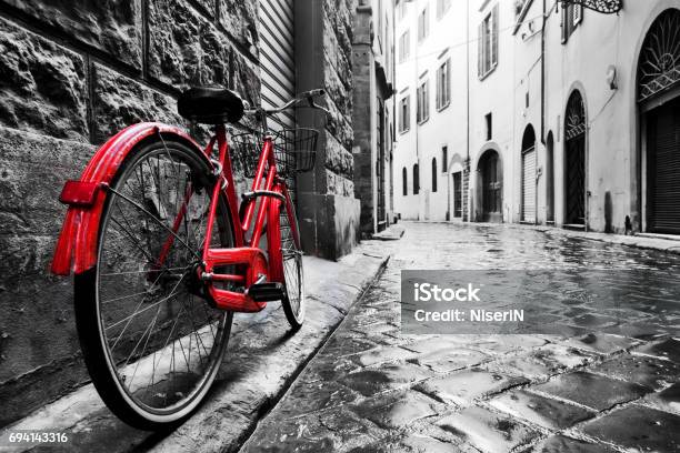 Retro Vintage Red Bike On Cobblestone Street In The Old Town Color In Black And White Stock Photo - Download Image Now