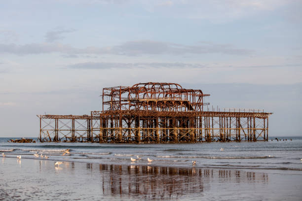 istock Old structure of a burned pier in the sea 694150030