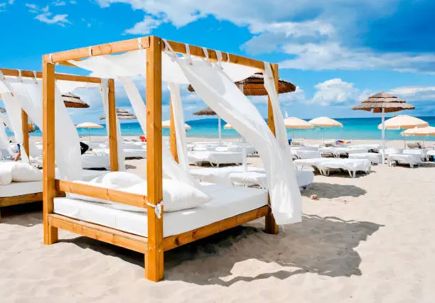 view of some beds in a beach club in a white sand beach in Ibiza, Spain
