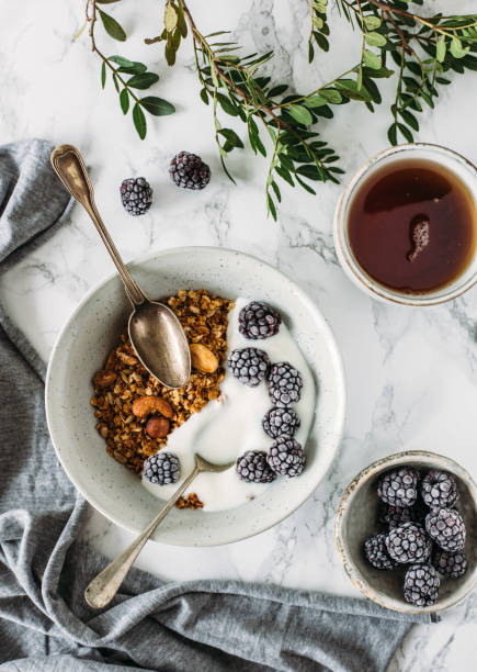 Having breakfast: granola and yogurt. Woman summer concept stock photo