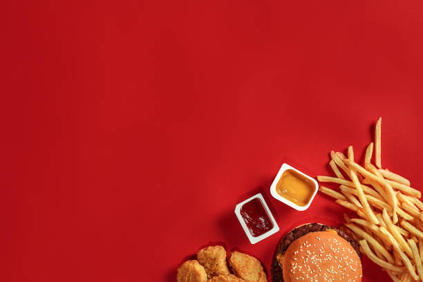 Burger and Chips. Hamburger and french fries in red paper box. Fast food on red background Burger and Chips. Hamburger and french fries in red paper box. Fast food on red background. Hamburger with tomato sauce. Top view, flat lay with copyspace pub table top view stock pictures, royalty-free photos & images