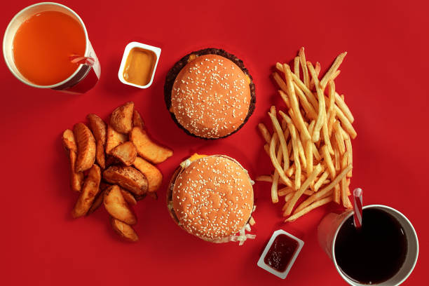 Burger and Chips. Hamburger and french fries in red paper box. Fast food on red background Burger and Chips. Hamburger and french fries in red paper box. Fast food on red background. Hamburger with tomato sauce. Top view, flat lay with copyspace pub table top view stock pictures, royalty-free photos & images