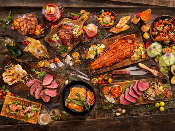 bbq Feast With: Salmon, Steaks, Beef Roast,pork tenderloin,pork chops, Halibut, Chicken wings, grilled fruit, breads and Drinks food table stock pictures, royalty-free photos & images