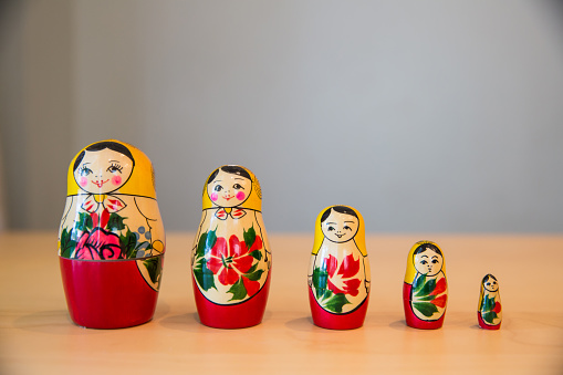 Various sized nesting dolls in a row on a table