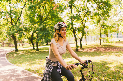 Mid adult woman riding bicycle in the public park