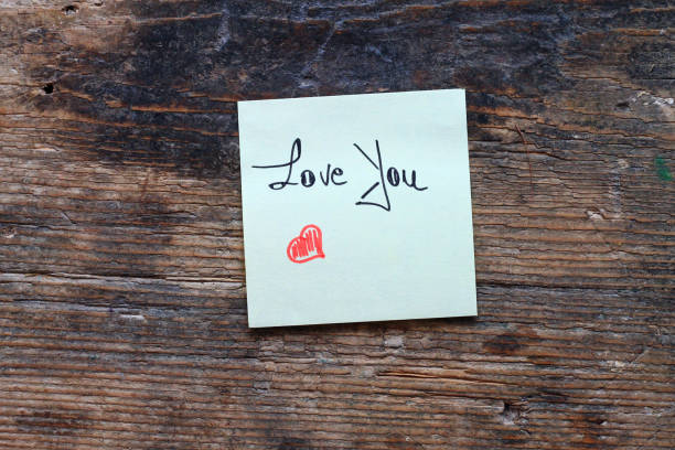 istock Message Love You with small red heart on wooden table 694189096