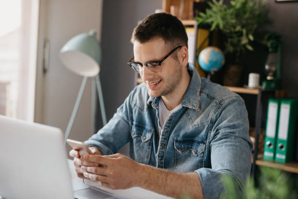 istock Man in denim shirt using a mobile phone 694195452